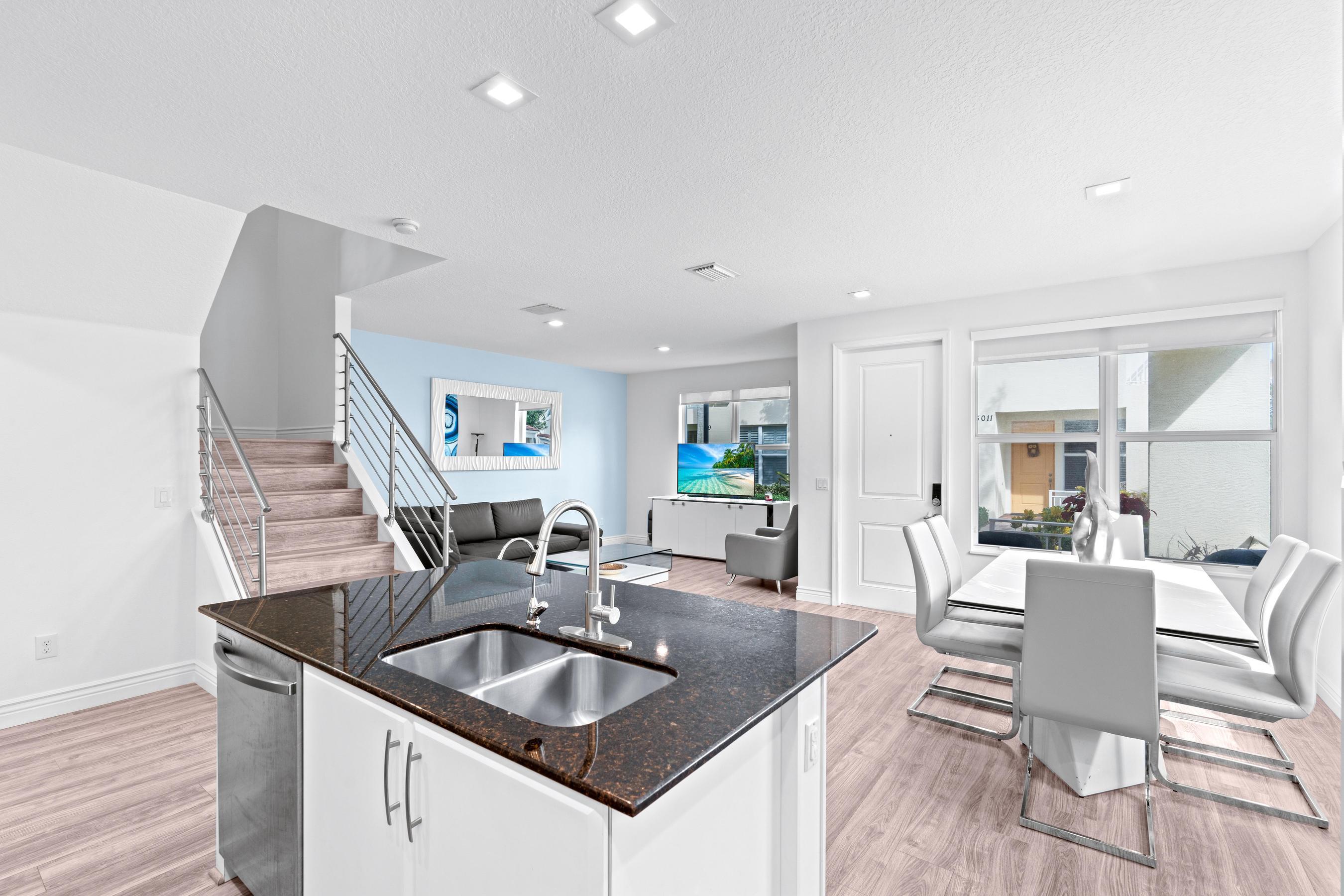 5010 Northwest 16th Way Boca Raton, FL 33431 - Photo 9 of 42 a kitchen with granite countertop a sink and a refrigerator