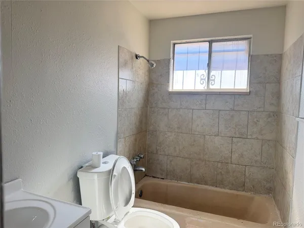a bathroom with a toilet a sink and bathtub