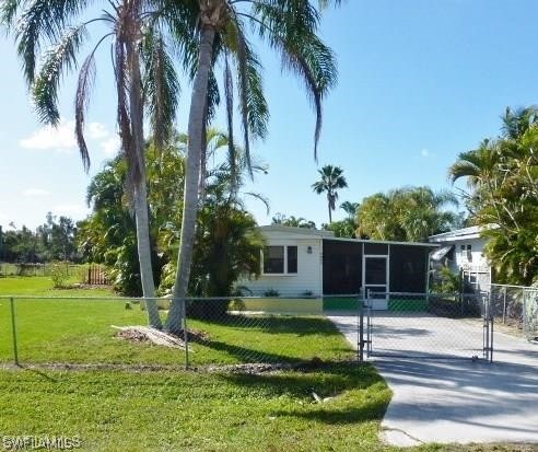 7351 Pinehurst Road Bokeelia, FL 33922 - Photo 1 of 31 a view of a house with a swimming pool and a big yard with palm trees