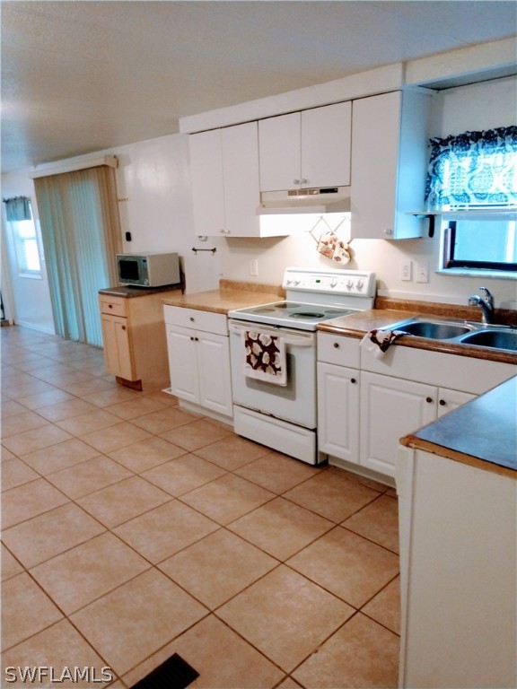 7351 Pinehurst Road Bokeelia, FL 33922 - Photo 11 of 31 a kitchen with granite countertop a stove a sink and a refrigerator