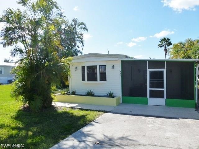 7351 Pinehurst Road Bokeelia, FL 33922 - Photo 2 of 31 a front view of a house with a garden and yard