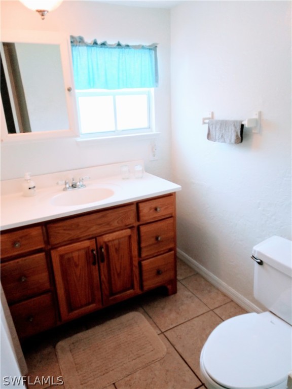 7351 Pinehurst Road Bokeelia, FL 33922 - Photo 26 of 31 a bathroom with a sink a toilet and a mirror