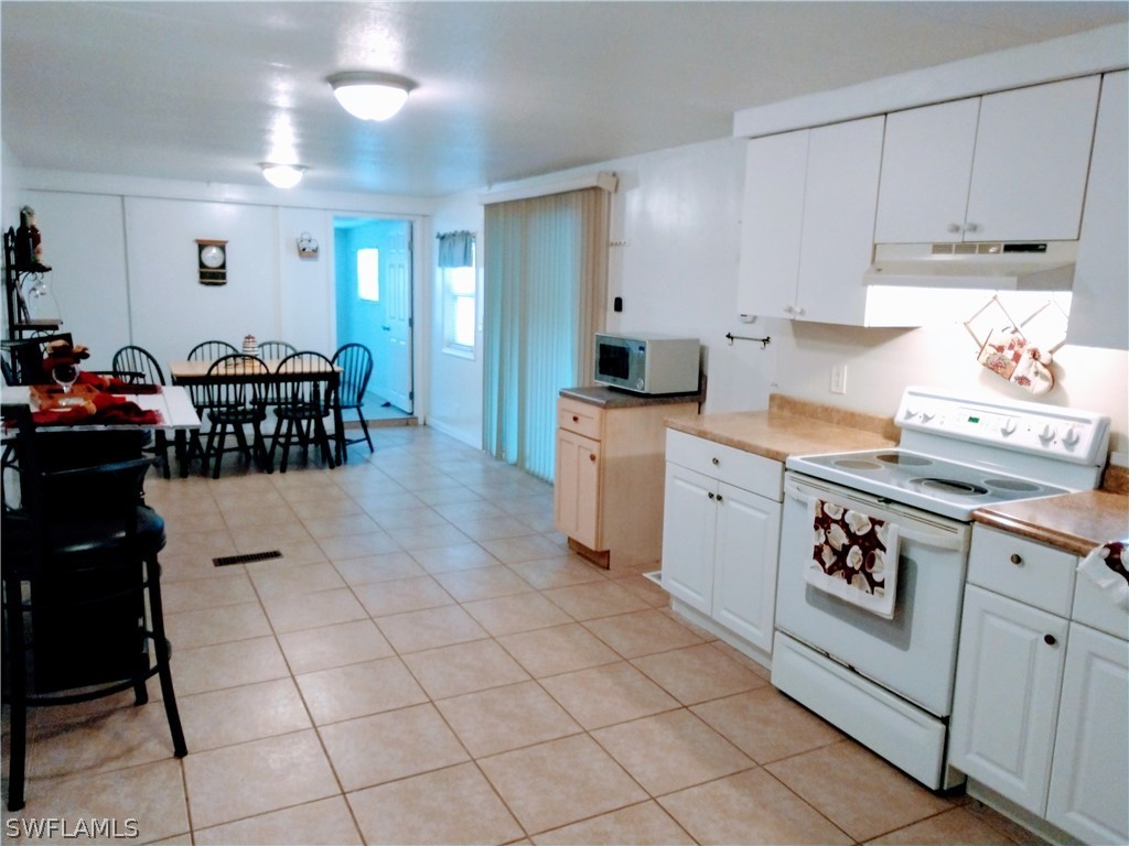 7351 Pinehurst Road Bokeelia, FL 33922 - Photo 9 of 31 a kitchen with a stove a sink and a refrigerator