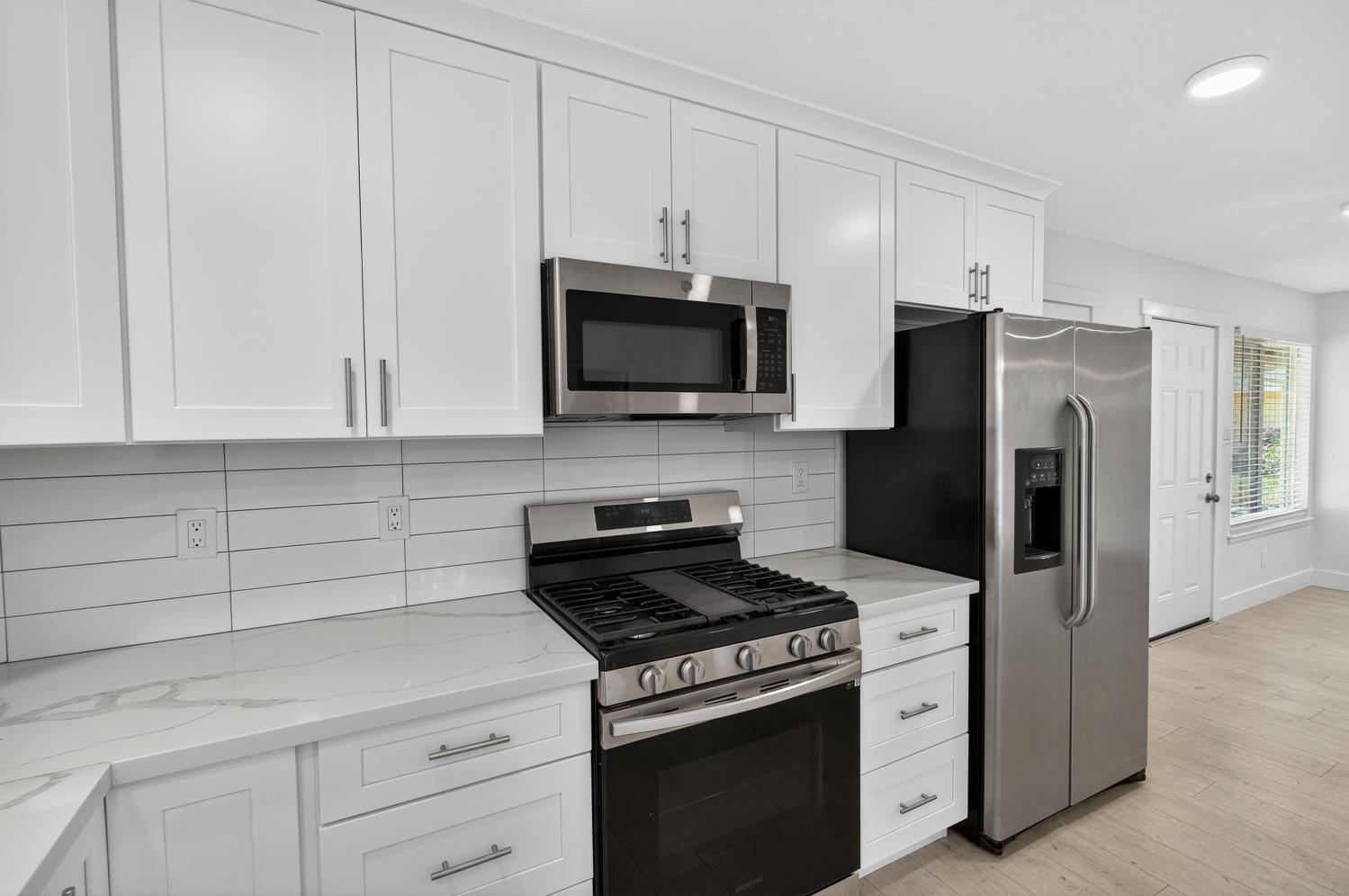 10457 Rockingham Drive Rancho Cordova, CA 95670 - Photo 18 of 49 a kitchen with stainless steel appliances white cabinets and a stove top oven