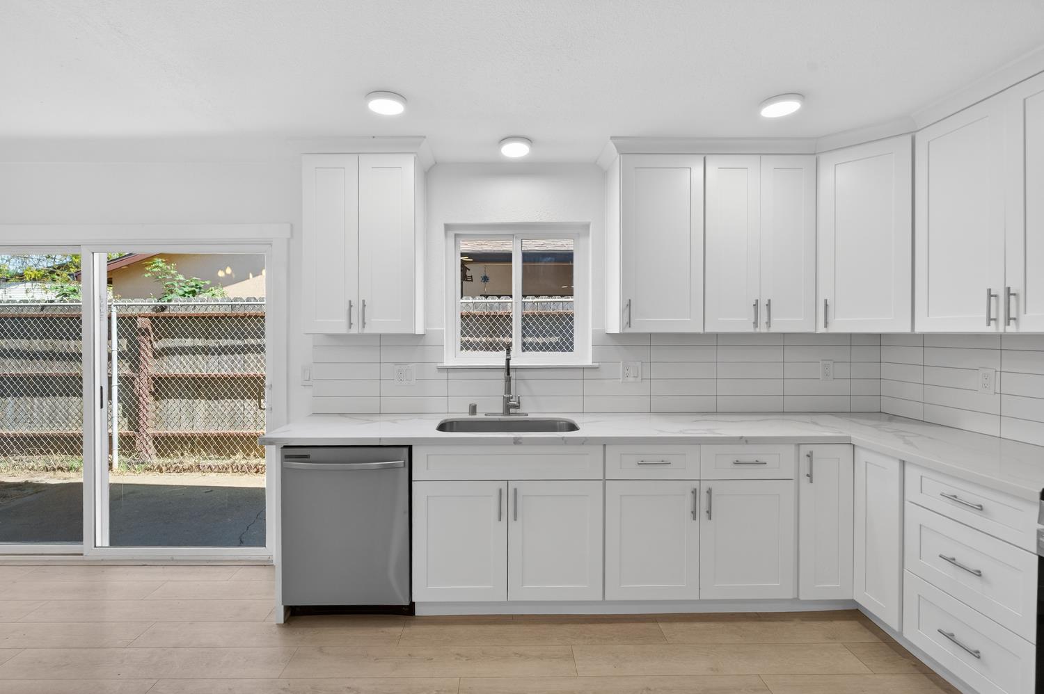 10457 Rockingham Drive Rancho Cordova, CA 95670 - Photo 5 of 49 a kitchen with white cabinets appliances a sink and a window