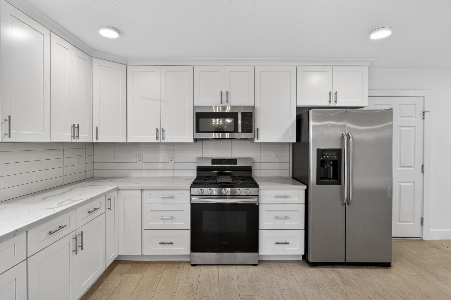 10457 Rockingham Drive Rancho Cordova, CA 95670 - Photo 6 of 49 a kitchen with white cabinets and stainless steel appliances