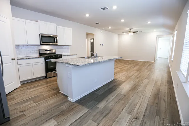 a kitchen with stainless steel appliances granite countertop wooden floors and granite counter tops