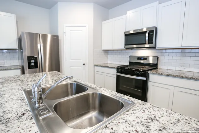 a kitchen with a sink stove and refrigerator