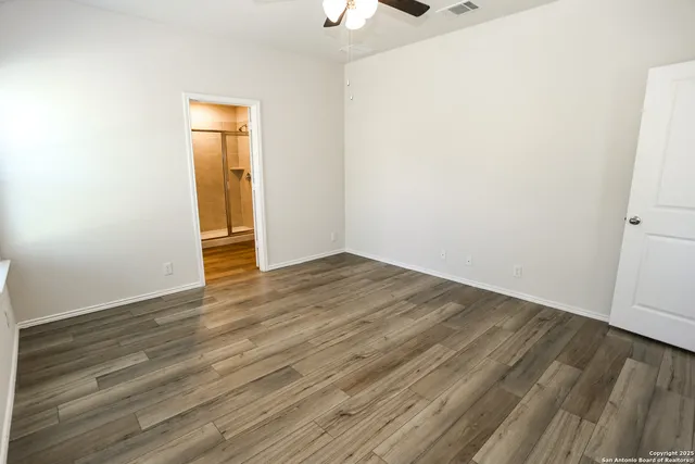a view of an empty room with wooden floor
