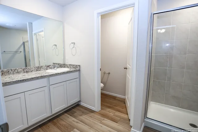 a bathroom with a granite countertop sink toilet and shower