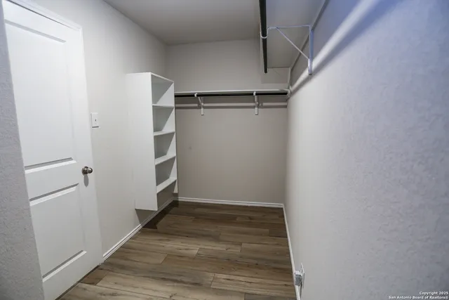 a view of walk in closet with empty racks