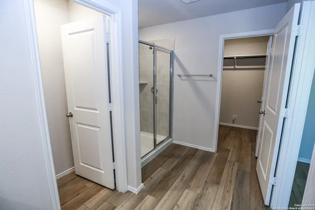 a view of a hallway with wooden floor and closet area