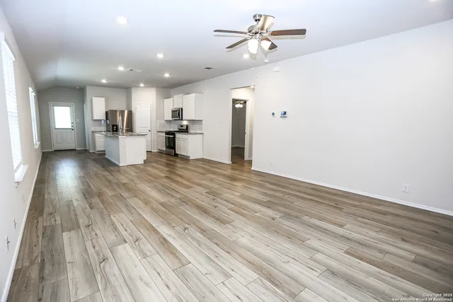 a view of a living room hardwood floor and a kitchen