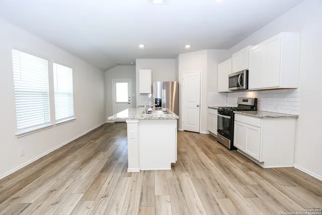 a kitchen with a refrigerator and a stove top oven