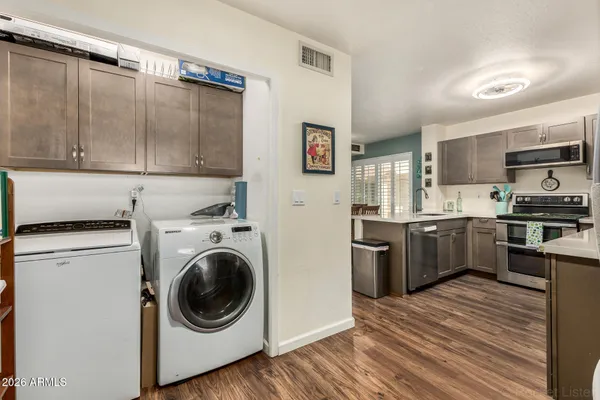 a kitchen with a refrigerator sink and wooden cabinets