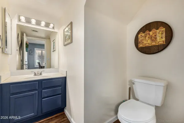 a bathroom with a toilet sink vanity and mirror
