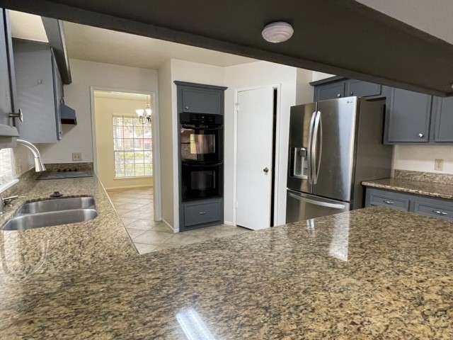 3003 Planters Street Sugar Land, TX 77479 - Photo 13 of 40 a kitchen with granite countertop a refrigerator and a sink