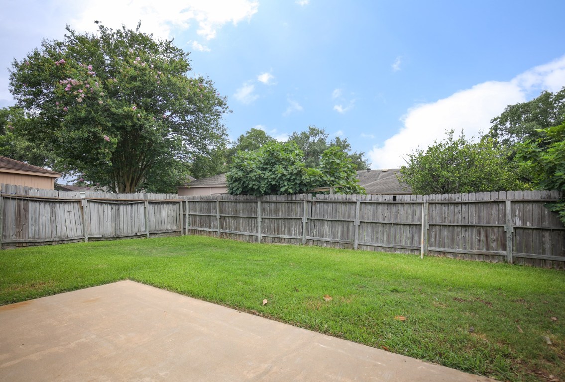 3003 Planters Street Sugar Land, TX 77479 - Photo 18 of 40 a backyard with a garden and wooden fence