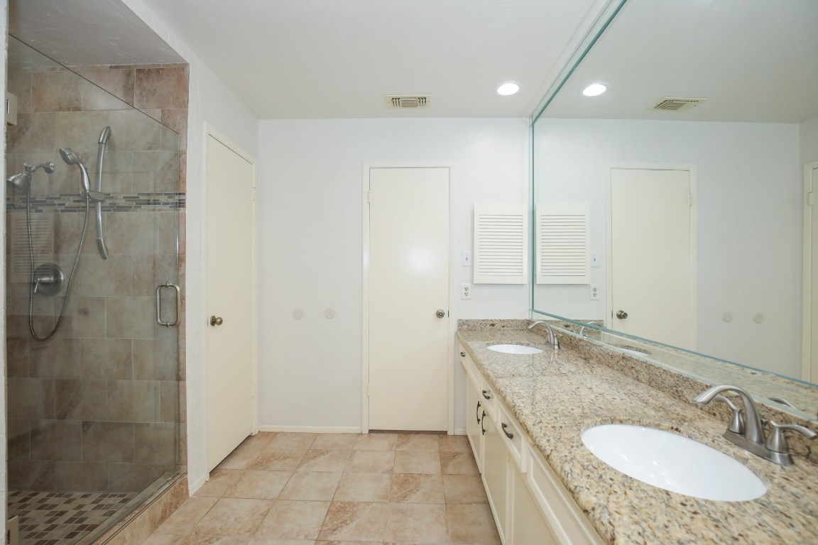 3003 Planters Street Sugar Land, TX 77479 - Photo 10 of 40 a bathroom with a granite countertop sink a mirror and shower