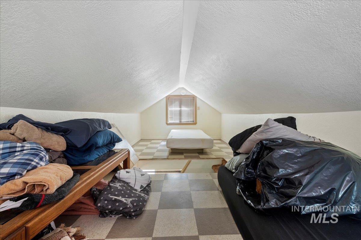815 Reedy Lane McCall, ID 83638 - Photo 13 of 22 Additional living space with a textured ceiling, lofted ceiling, and tile patterned floors