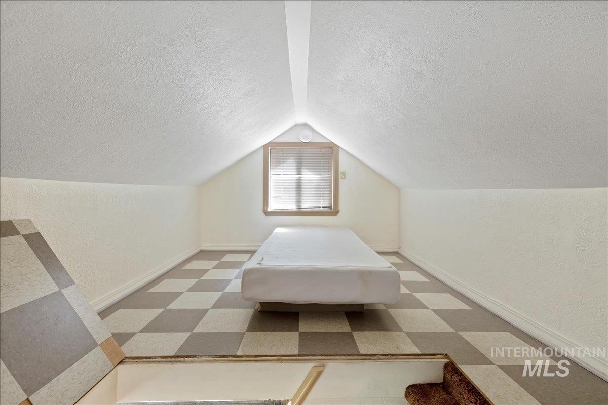 815 Reedy Lane McCall, ID 83638 - Photo 14 of 22 Unfurnished bedroom featuring a textured ceiling, vaulted ceiling, light flooring, and a textured wall