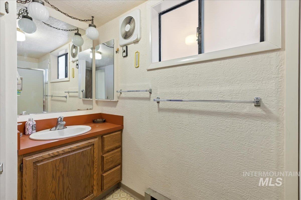 815 Reedy Lane McCall, ID 83638 - Photo 15 of 22 Full bathroom featuring vanity, a stall shower, a textured ceiling, and a textured wall