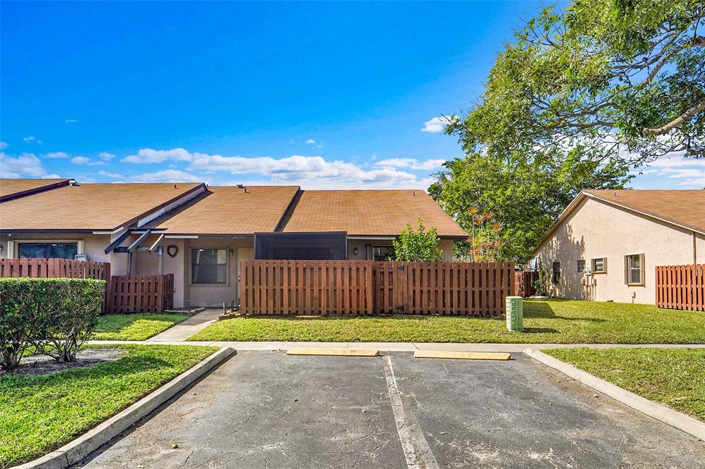 a view of a house with a big yard plants and large trees