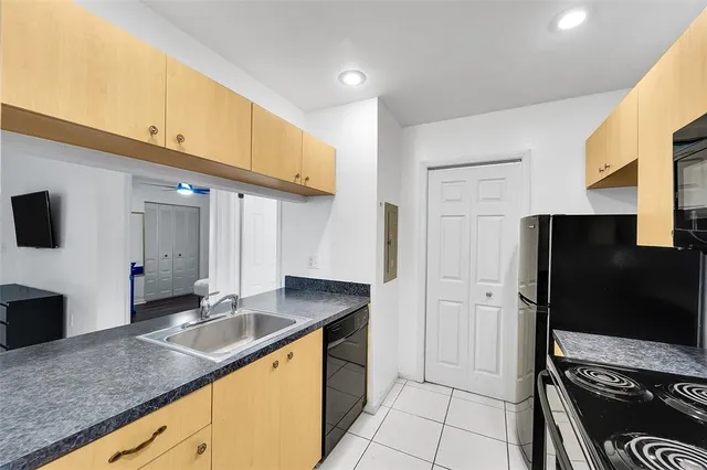 a kitchen with granite countertop a refrigerator and a sink