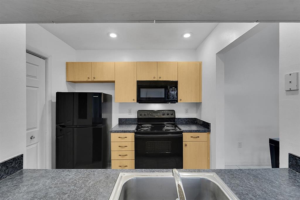 2698 North Nob Hill Road Sunrise, FL 33322 - Photo 7 of 27 a kitchen with a refrigerator and a stove top oven
