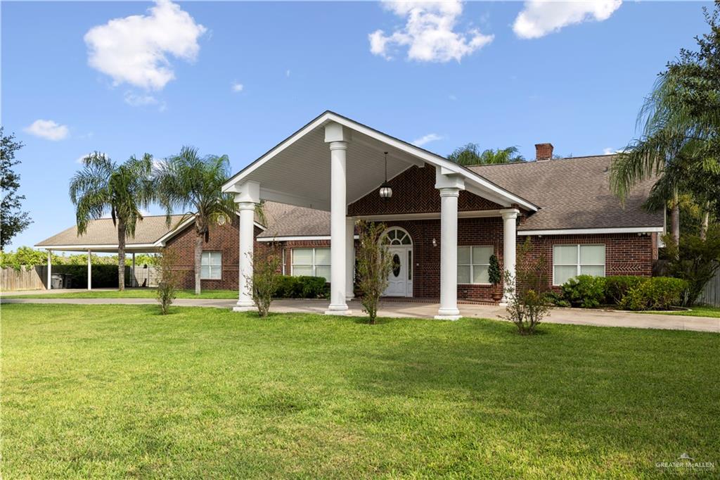 a front view of a house with a yard and trees