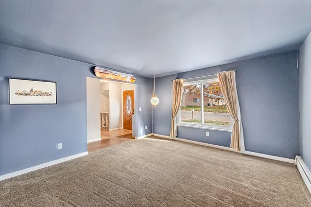 a view of empty room with window and ceiling fan