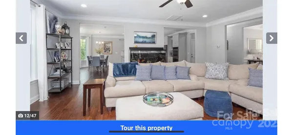 a kitchen with stainless steel appliances granite countertop a stove top oven a sink dishwasher and white cabinets with wooden floor