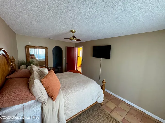 a bedroom with a bed and a flat tv screen on dresser
