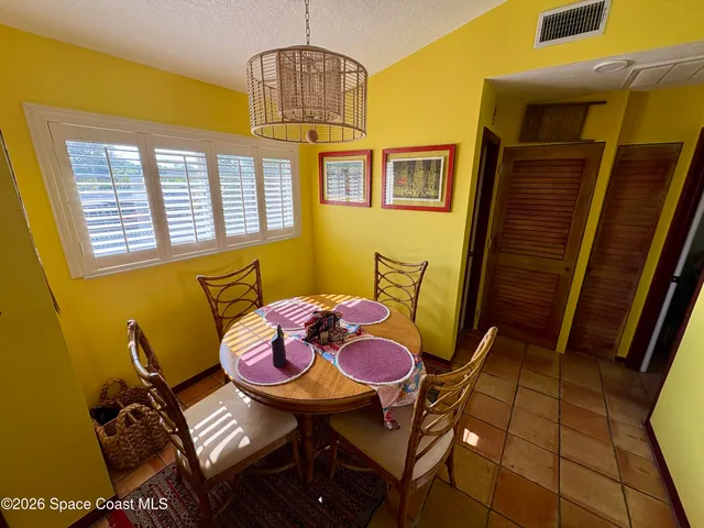 a view of a dining room with furniture and a chandelier