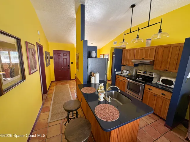 a kitchen with stainless steel appliances granite countertop a sink a stove and a refrigerator