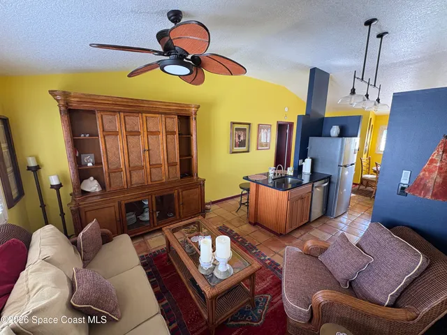 a living room with furniture a dining table and a chandelier