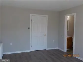 an empty room with wooden floor and closet