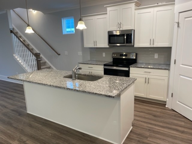 525 Black Tea Way Franklin, TN 37064 - Photo 25 of 51 a kitchen with granite countertop a stove a microwave and wooden floor