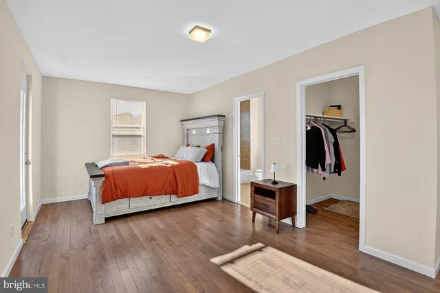 a bedroom with wooden floor and a bed