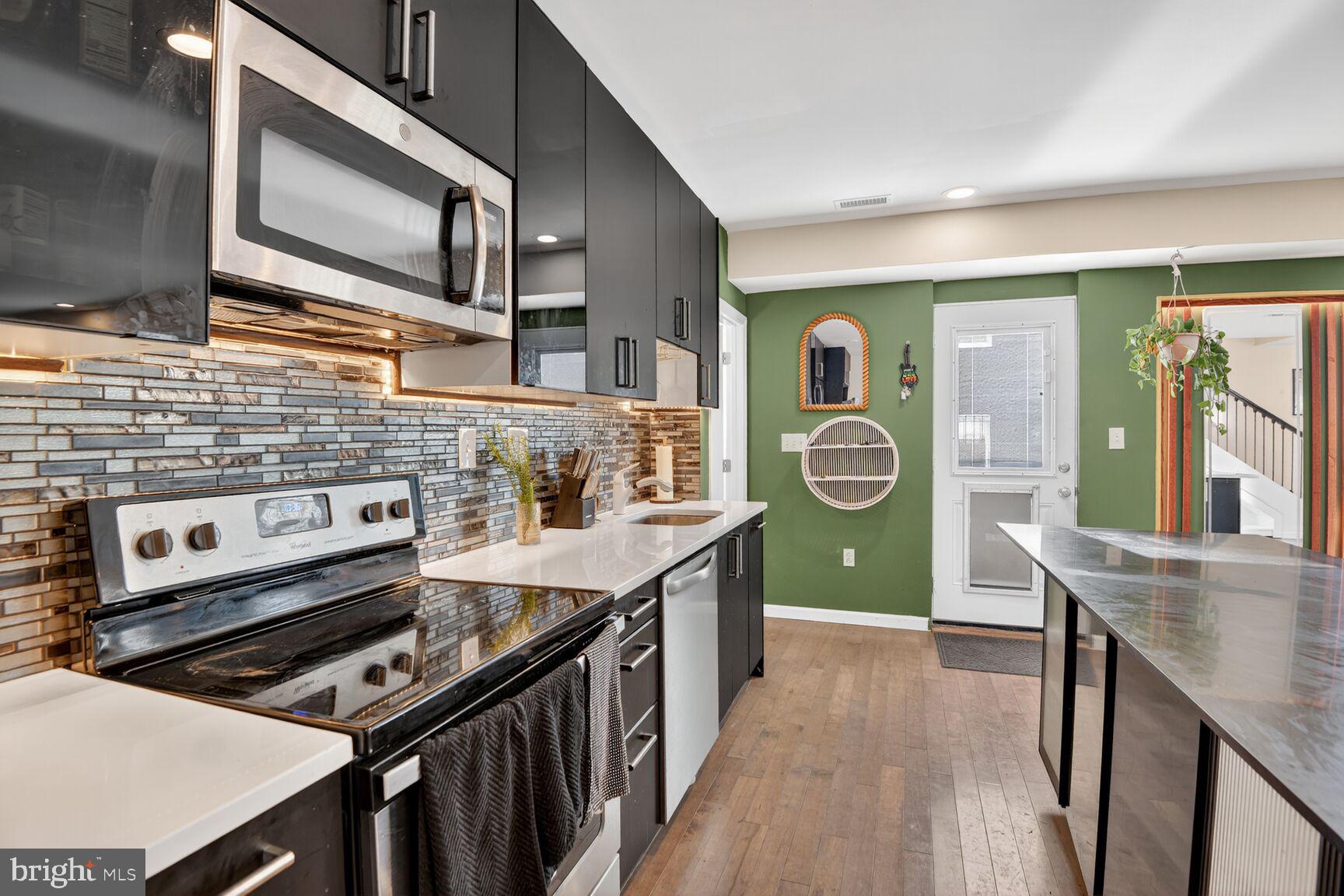 4321 Minnesota Avenue Northeast Washington, DC 20019 - Photo 7 of 24 a kitchen with a stove a sink and wooden floors