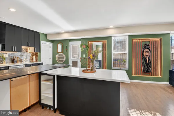 a kitchen with a sink a window and chairs