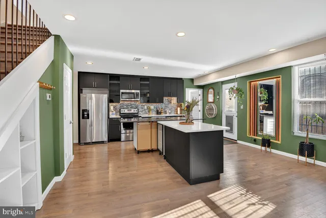 a large kitchen with a large counter top stainless steel appliances and cabinets