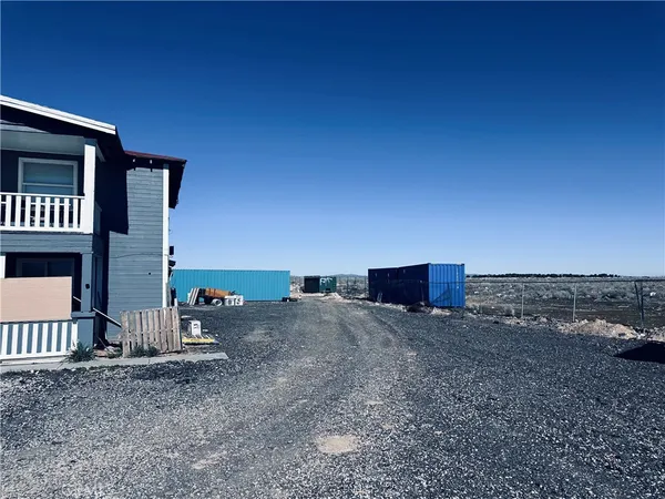 a view of a dry yard with wooden fence