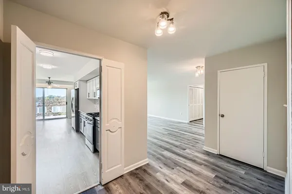 a view of a hallway with wooden floor and chandelier