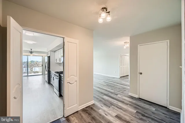 a view of a hallway with wooden floor and chandelier