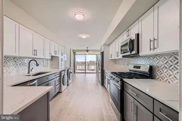 a kitchen with stainless steel appliances granite countertop a stove sink microwave and cabinets