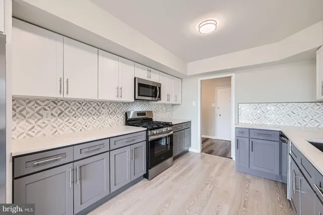 a kitchen with granite countertop white cabinets and stainless steel appliances