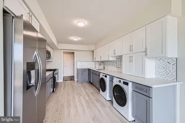 a view of kitchen with stainless steel appliances cabinets and wooden floor