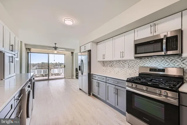 a kitchen with stainless steel appliances kitchen island granite countertop a stove and a microwave
