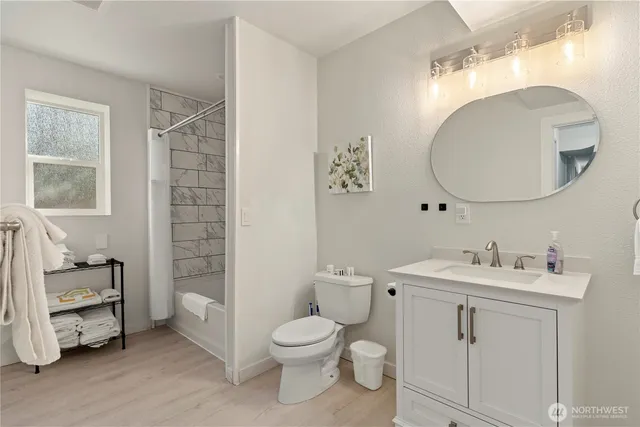 a bathroom with a toilet a sink a mirror and a window